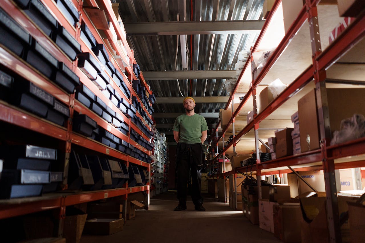 man-in-green-shirt-standing-in-the-storeroom